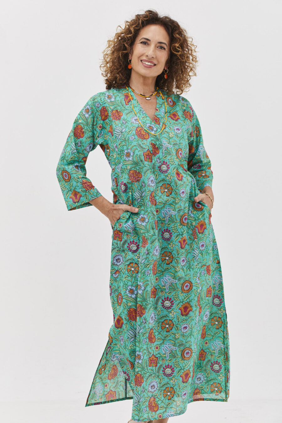 גלביה לנשים | גלבייה בעיצוב ייחודי – פרינט סימפוני, שמלה בצבע טורקיז ירקרק עם הדפס פרחוני צבעוני.