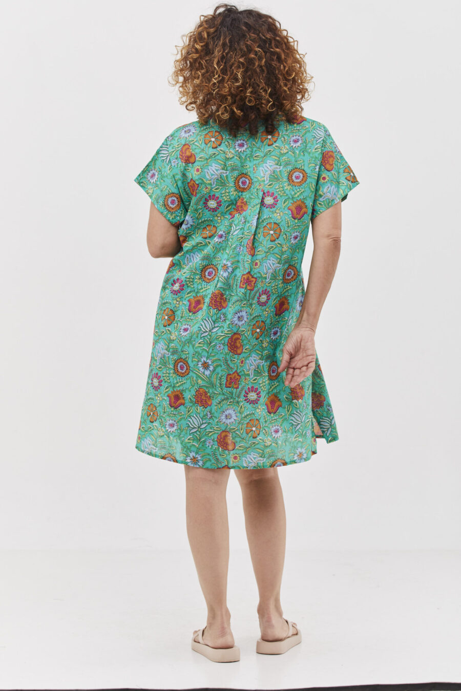 שמלת סיגי | שמלת אוברסייז קצרה בעיצוב ייחודי לכל המידות כולל מידות גדולות - פרינט סימפוני, שמלה בצבע טורקיז ירקרק עם הדפס פרחוני צבעוני.