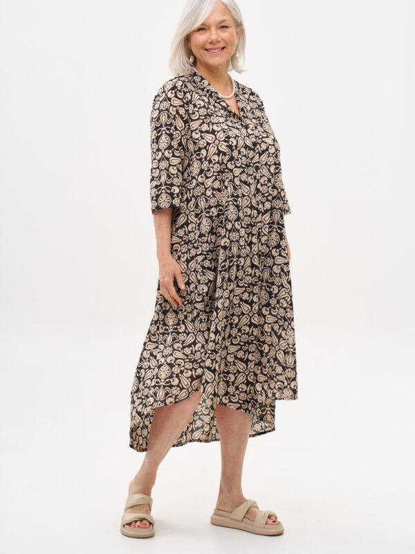 שמלת איה'לה | שמלת אוברסייז בעיצוב ייחודי – פרינט טוליפ שחור, שמלה שחורה עם הדפס פרחוני בז'.