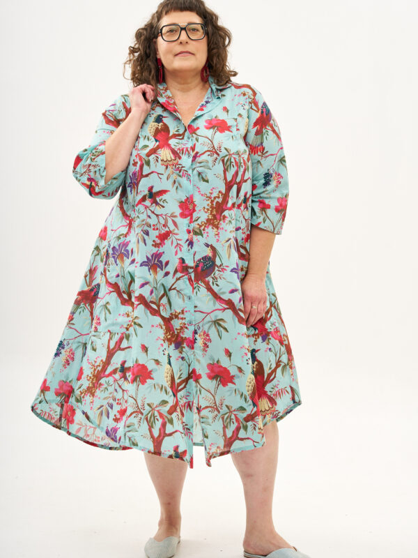 שמלת איה'לה | שמלת אוברסייז בעיצוב ייחודי – פרינט טרופיקנה, הדפס טרופי על רקע שמלה בצבע טורקיז.