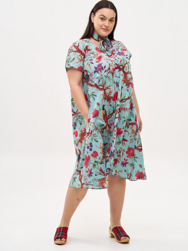 שמלת ג'וז | שמלת אוברסייז באורך מידי בעיצוב ייחודי - פרינט טרופיקנה, הדפס טרופי על רקע מכנסיים בצבע טורקיז.