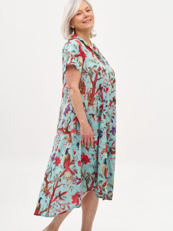 שמלת איה'לה | שמלת אוברסייז בעיצוב ייחודי – פרינט טרופיקנה, הדפס טרופי על רקע שמלה בצבע טורקיז.