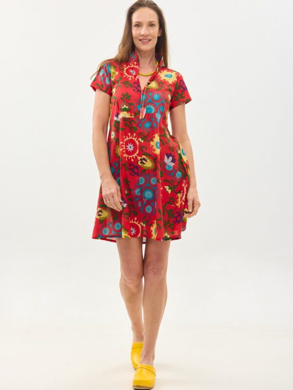קומפורט זון: שמלת הילי | סוזני אדום. פרינט פלורילי בצהובים, ירוקים ותוכלים על רקע אדום לוהב. שמלה קצרה עם צווארון יפני בשילוב רוכסן, עם שרוולים קצרים וכיסים