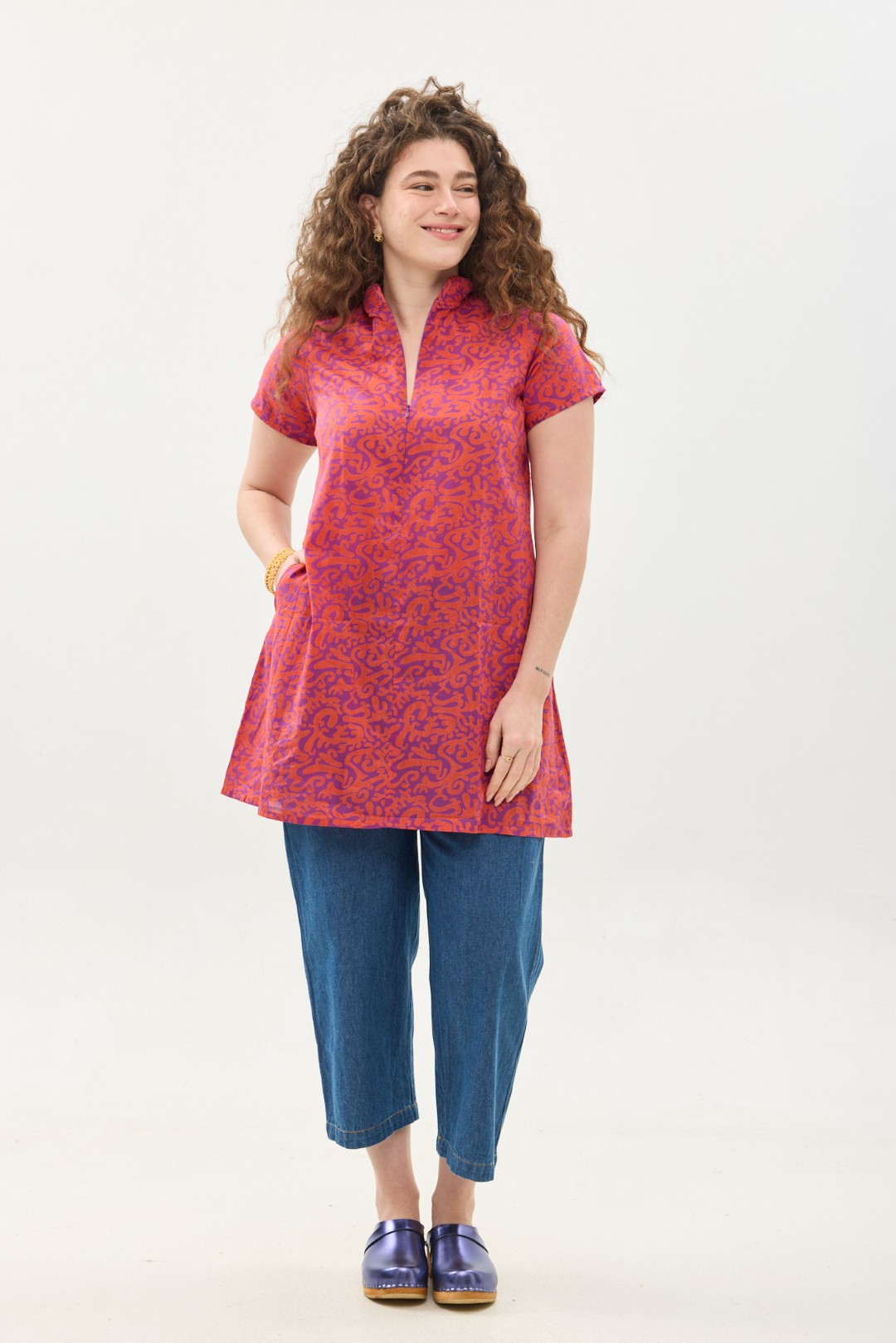 קומפורט זון: טוניקת מאיקו | טוניקה יפנית בעלת מפתח בעיצוב ייחודי. פרינט הפי פנטזי: דגם אוריינטלי ורוד כתום על רקע סגול. טוניקה באורך מחצית הירך, צווארון גבוה בשילוב רוכסן עמוק, עם שרוולים קצרים.