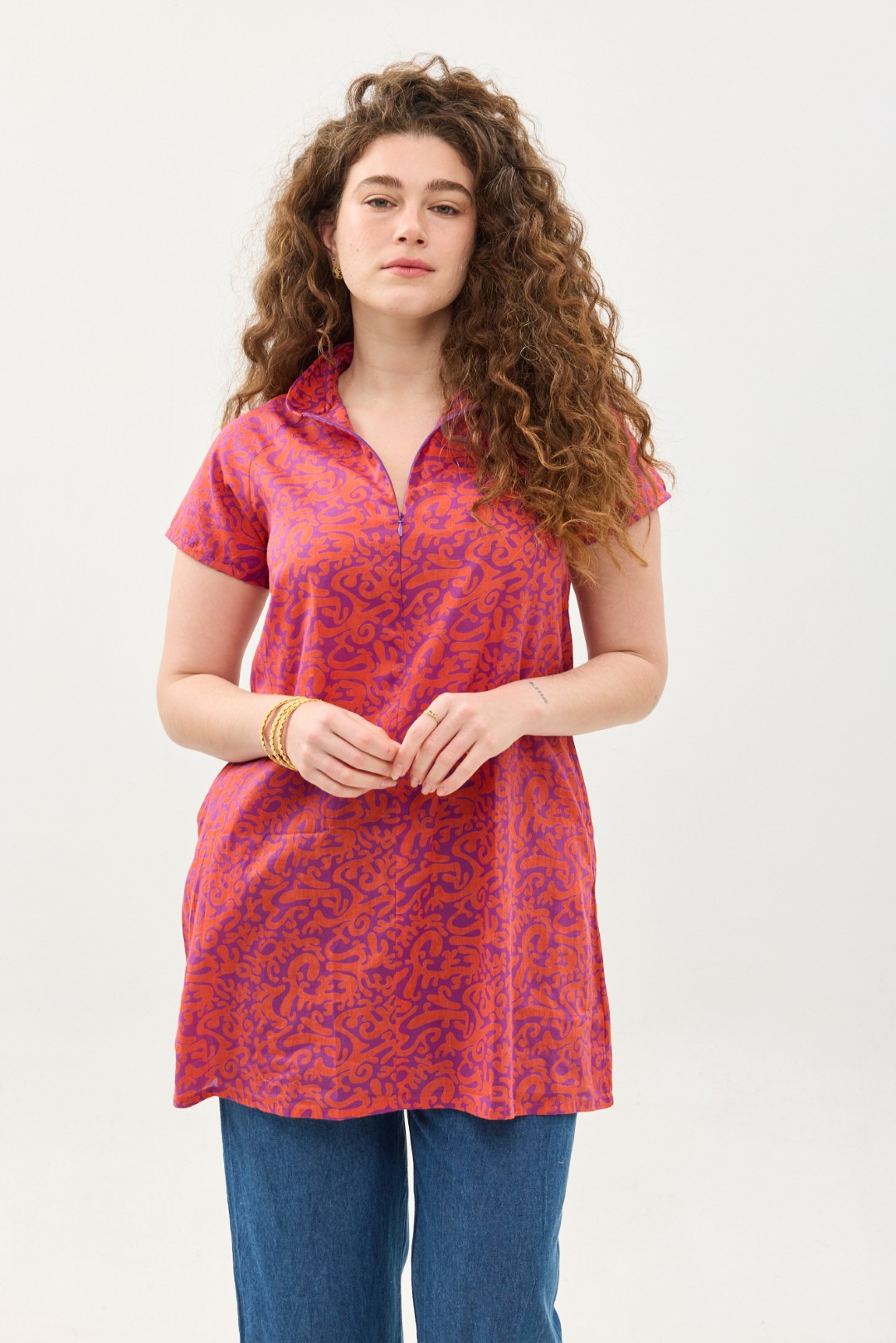 קומפורט זון: טוניקת מאיקו | טוניקה יפנית בעלת מפתח בעיצוב ייחודי. פרינט הפי פנטזי: דגם אוריינטלי ורוד כתום על רקע סגול. טוניקה באורך מחצית הירך, צווארון גבוה בשילוב רוכסן עמוק, עם שרוולים קצרים.