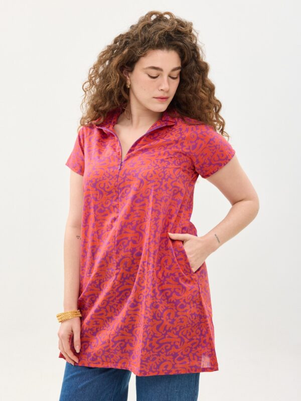 קומפורט זון: טוניקת מאיקו | טוניקה יפנית בעלת מפתח בעיצוב ייחודי. פרינט הפי פנטזי: דגם אוריינטלי ורוד כתום על רקע סגול. טוניקה באורך מחצית הירך, צווארון גבוה בשילוב רוכסן עמוק, עם שרוולים קצרים.