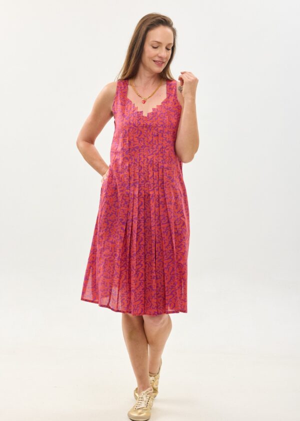 קומפורט זון: שמלת היידי | הפי פנטזי, פרינט של דגם אוריינטלי ורוד כתום על רקע סגול. שמלת גופיה באורך מתחת הברך, עם כתפיות רחבות, מפתח גאומטרי ואלמנט פליסה בחזית למראה מתוחכם