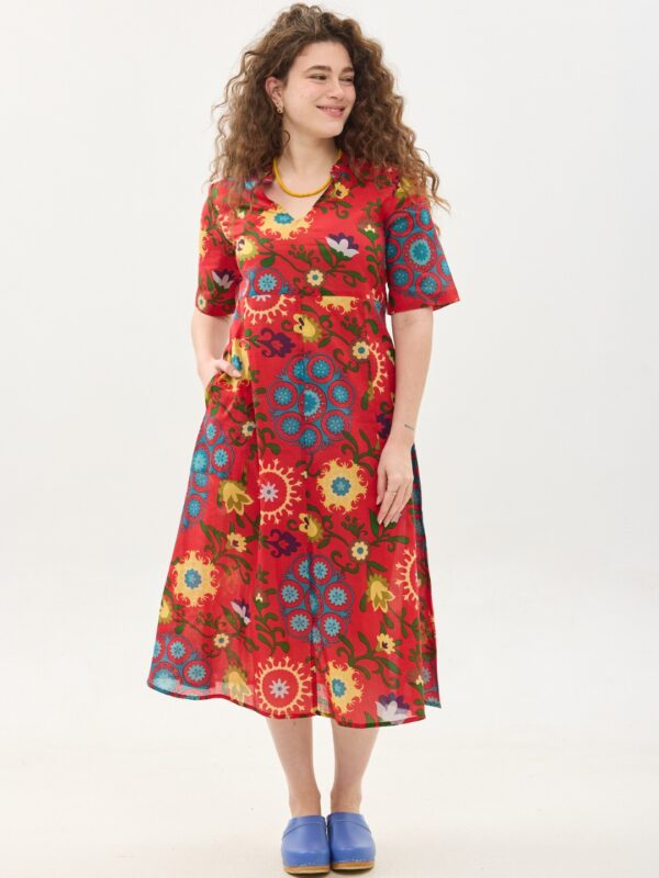 קומפורט זון: שמלת גילי | סוזני אדום. פרינט פלורילי בצהובים, ירוקים ותכולים על רקע אדום לוהב. שמלת אוברסייז מידי יפיפיה ונוחה עם צווארון וי, שרוולים עד המרפק, כיסים ותפר מדגיש מתחת לחזה.