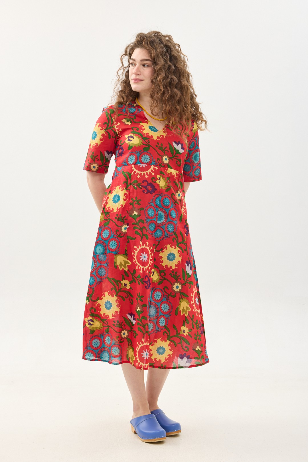 קומפורט זון: שמלת גילי | סוזני אדום. פרינט פלורילי בצהובים, ירוקים ותכולים על רקע אדום לוהב. שמלת אוברסייז מידי יפיפיה ונוחה עם צווארון וי, שרוולים עד המרפק, כיסים ותפר מדגיש מתחת לחזה.