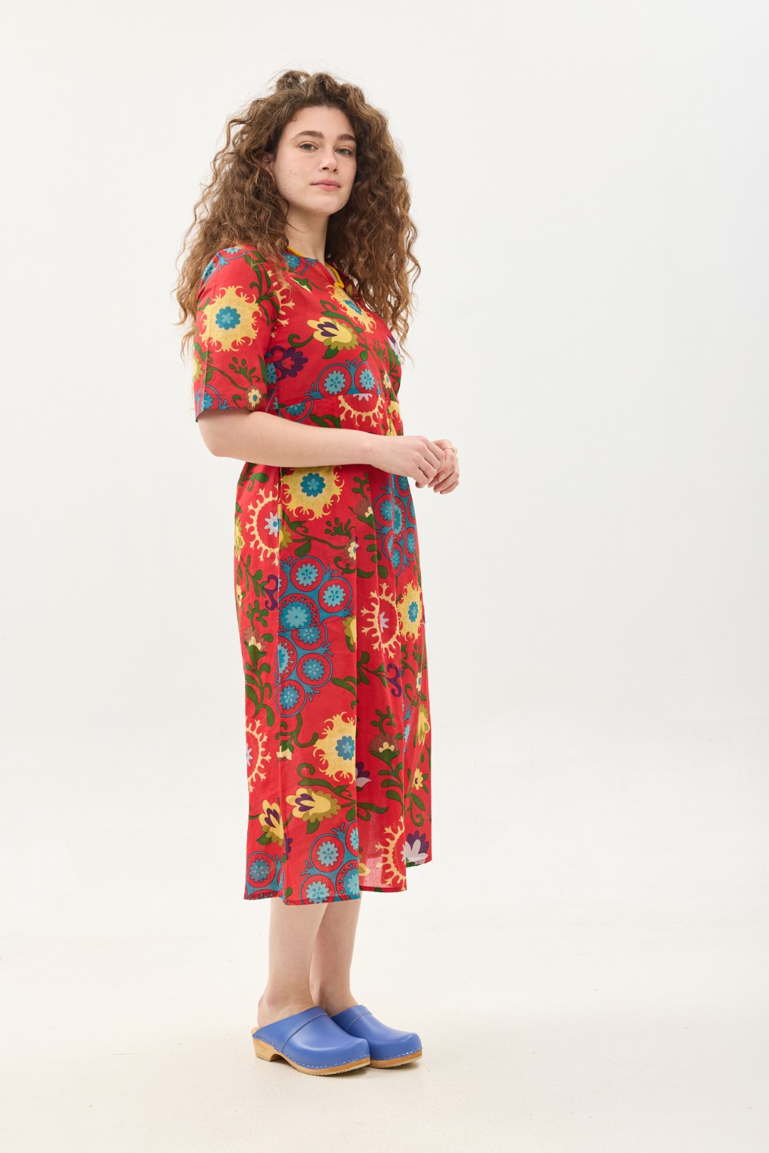 קומפורט זון: שמלת גילי | סוזני אדום. פרינט פלורילי בצהובים, ירוקים ותכולים על רקע אדום לוהב. שמלת אוברסייז מידי יפיפיה ונוחה עם צווארון וי, שרוולים עד המרפק, כיסים ותפר מדגיש מתחת לחזה.