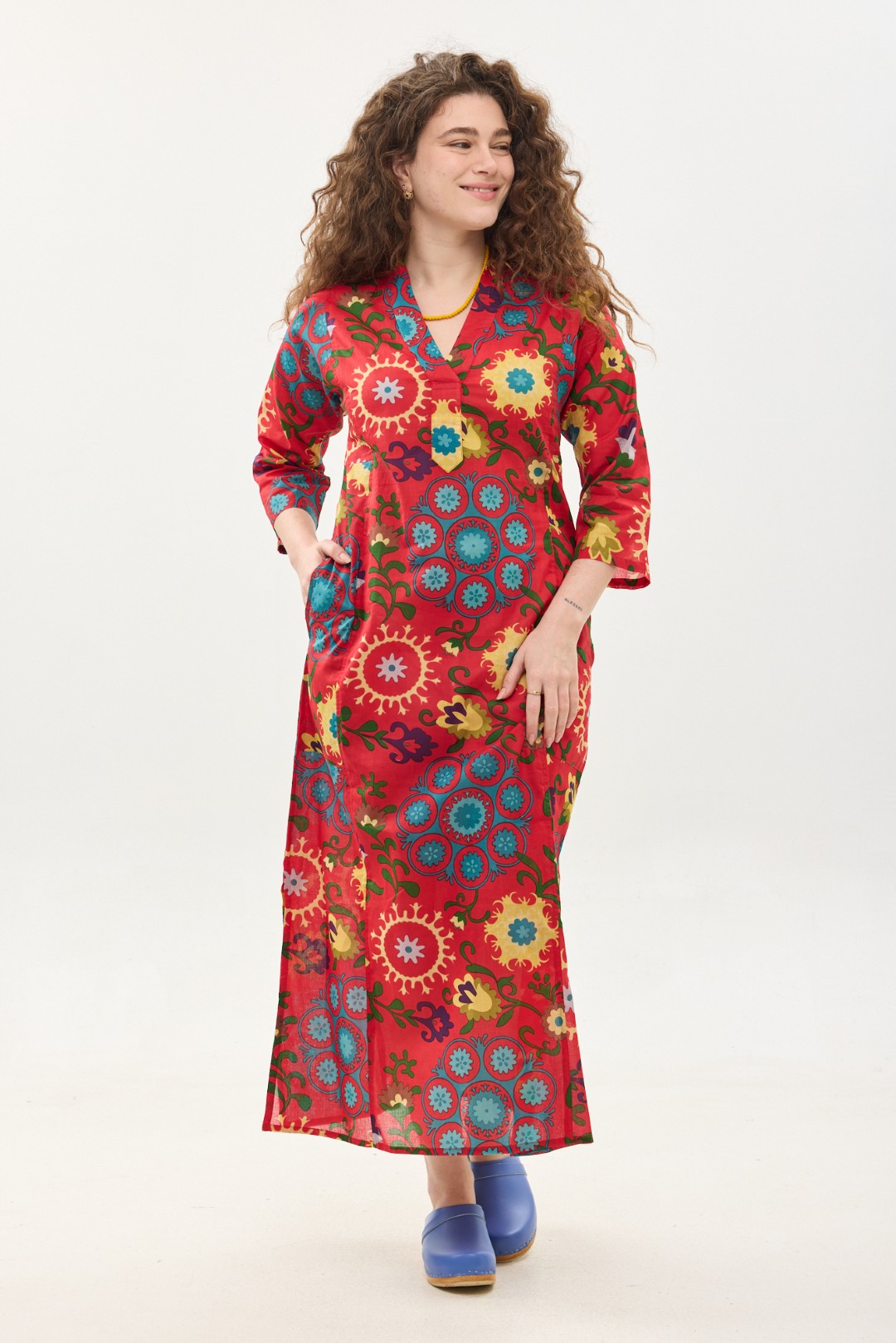 גלביה לנשים | סוזני אדום. גלבייה בעיצוב ייחודי - פרינט פלורילי בצהובים, ירוקים ותכולים על רקע אדום לוהב. שמלת גלביה נעימה ונוחה באורך הקרסול, צווארון ווי, שרוולים 3/4 וכיסים צדדיים