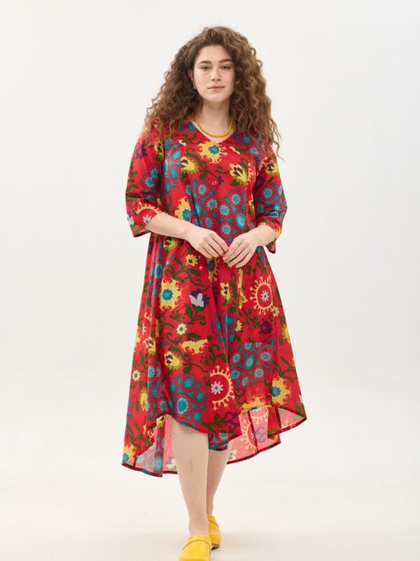 קומפורט זון: שמלת יפעת | סוזני אדום. פרינט פלורילי בצהובים, ירוקים ותכולים על רקע אדום לוהב. שמלת אוברסייז יפיפייה ונוחה, צווארון וי, שרוולים 3/4, כפתורים וכיסים קדמיים.