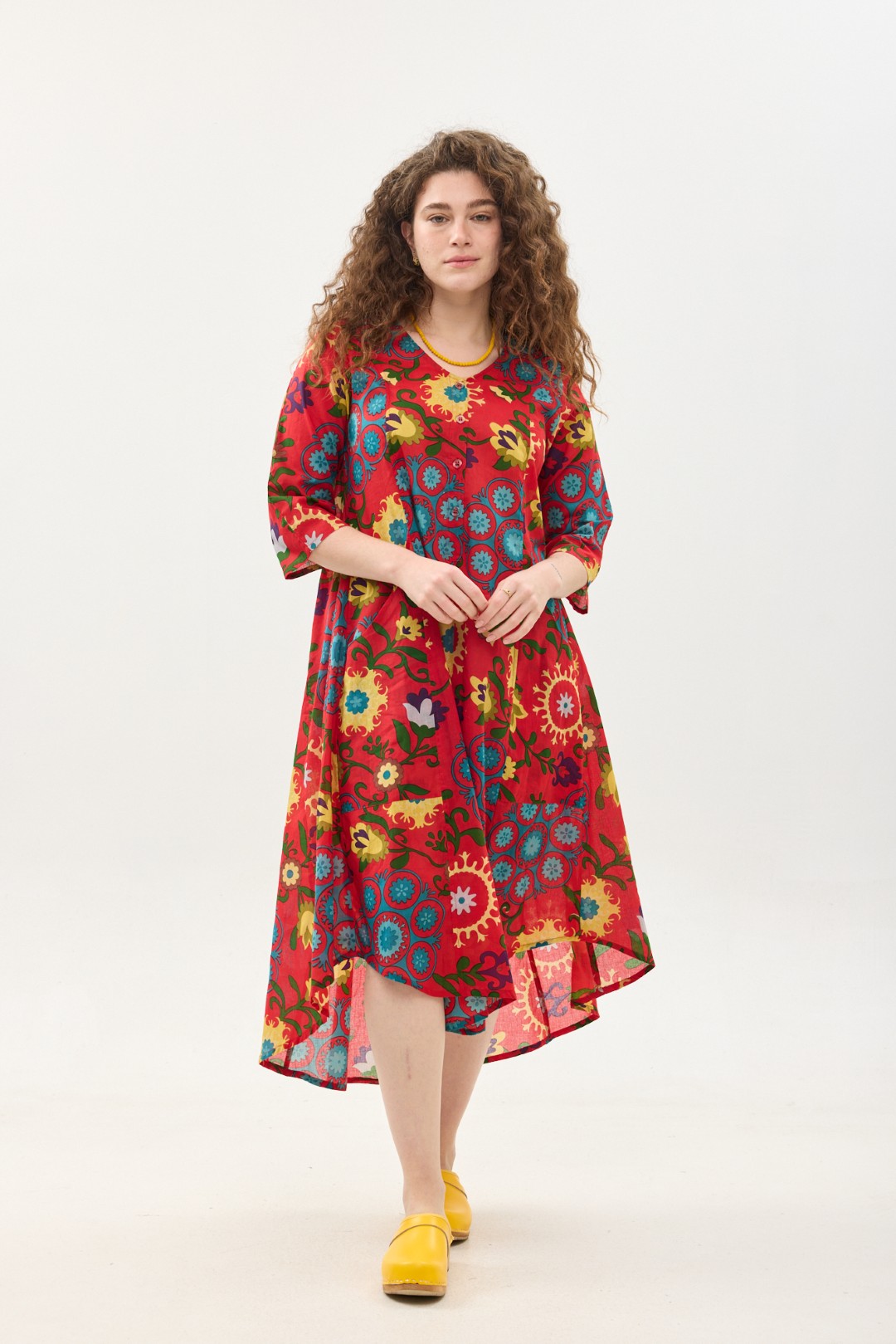 קומפורט זון: שמלת יפעת | סוזני אדום. פרינט פלורילי בצהובים, ירוקים ותכולים על רקע אדום לוהב. שמלת אוברסייז יפיפייה ונוחה, צווארון וי, שרוולים 3/4, כפתורים וכיסים קדמיים.