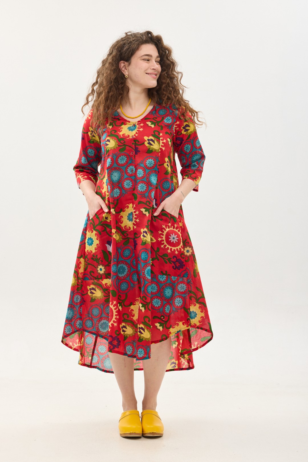 קומפורט זון: שמלת יפעת | סוזני אדום. פרינט פלורילי בצהובים, ירוקים ותכולים על רקע אדום לוהב. שמלת אוברסייז יפיפייה ונוחה, צווארון וי, שרוולים 3/4, כפתורים וכיסים קדמיים.