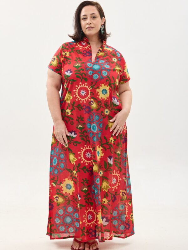 קומפורט זון: שמלת מאיקו, שרוול קצר | סוזני אדום. שמלת מקסי יפיפיה ונוחה, צווארון גבוה בשילוב רוכסן עמוק, עם שרוולים קצרים וכיסים. פרינט פלורילי בצהובים, ירוקים ותכולים על רקע אדום לוהב.