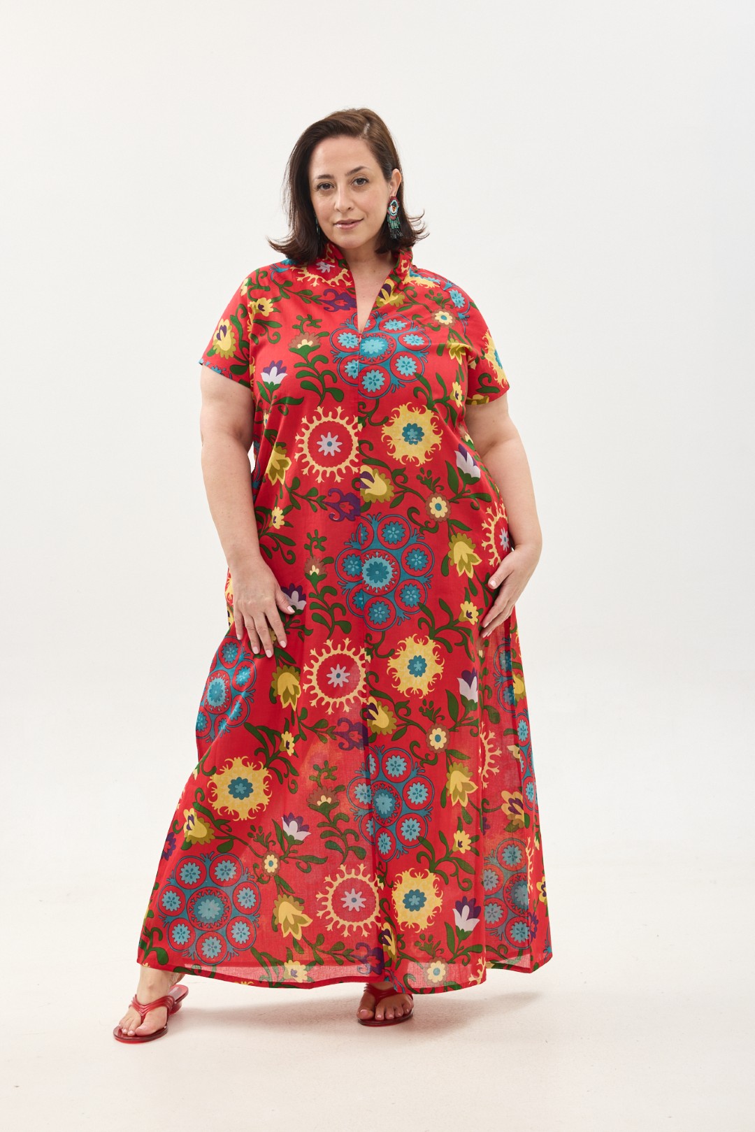 קומפורט זון: שמלת מאיקו, שרוול קצר | סוזני אדום. שמלת מקסי יפיפיה ונוחה, צווארון גבוה בשילוב רוכסן עמוק, עם שרוולים קצרים וכיסים. פרינט פלורילי בצהובים, ירוקים ותכולים על רקע אדום לוהב.