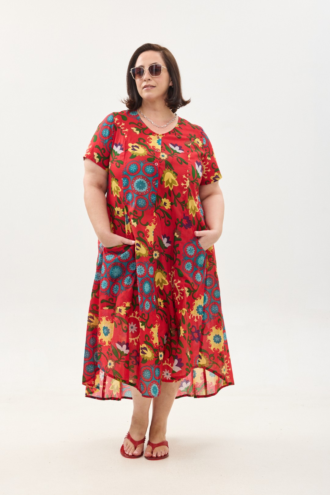 קומפורט זון: שמלת יפעת, שרוול קצר | סוזני אדום. פרינט פלורילי בצהובים, ירוקים ותכולים על רקע אדום לוהב. שמלת אוברסייז יפיפייה ונוחה, צווארון עגול, שרוולים קצרים, כפתורים מלמעלה עד למטה וכיסים קדמיים.