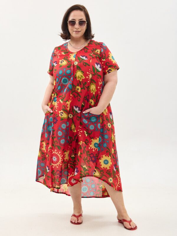 קומפורט זון: שמלת יפעת, שרוול קצר | סוזני אדום. פרינט פלורילי בצהובים, ירוקים ותכולים על רקע אדום לוהב. שמלת אוברסייז יפיפייה ונוחה, צווארון עגול, שרוולים קצרים, כפתורים מלמעלה עד למטה וכיסים קדמיים.
