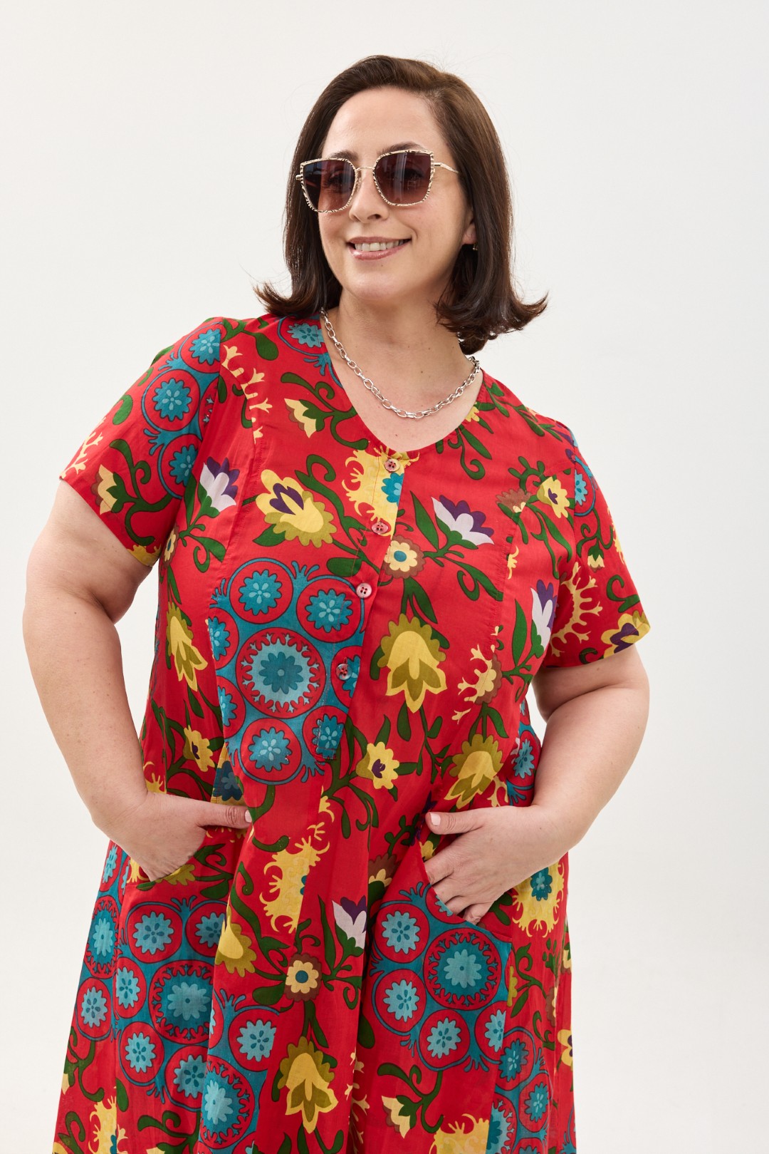 קומפורט זון: שמלת יפעת, שרוול קצר | סוזני אדום. פרינט פלורילי בצהובים, ירוקים ותכולים על רקע אדום לוהב. שמלת אוברסייז יפיפייה ונוחה, צווארון עגול, שרוולים קצרים, כפתורים מלמעלה עד למטה וכיסים קדמיים.